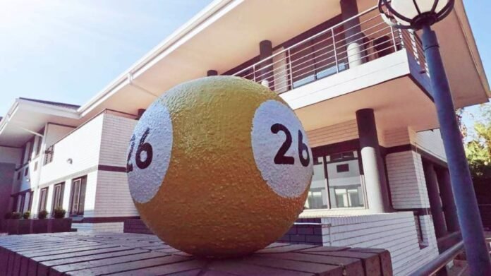 Lottery ball showing 16 and 26 outside Sizekhaya Holdings offices in daylight.