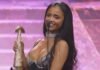 SAMA 2026: How Tyla gave anticlimactic awards night its big moment Tyla smiles at a microphone while holding her SAMA32 trophy on stage.