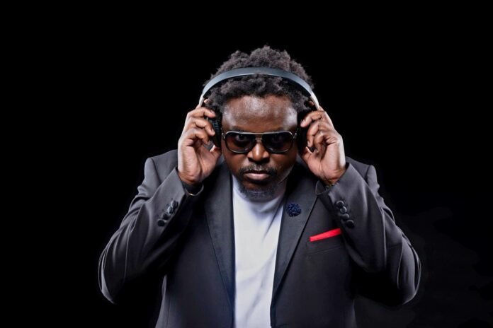DJ MidTempo Theo Mseka in a black suit holding headphones for his Cheza Kidogo debut Afro House album.