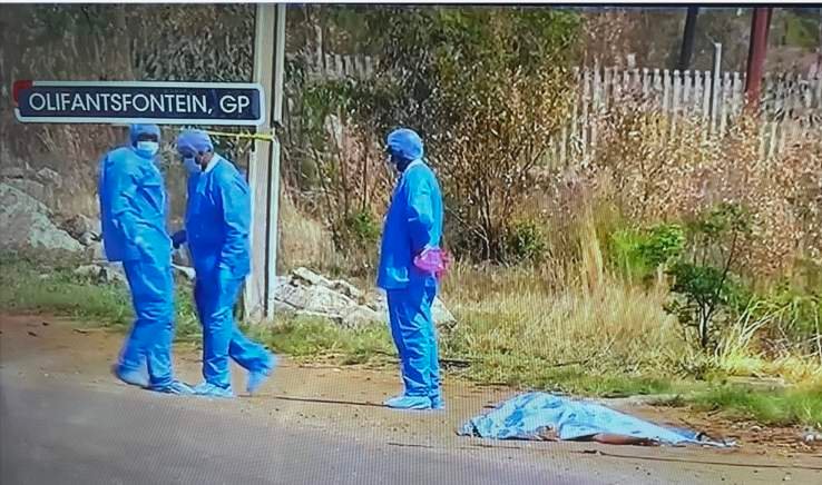 Forensic investigators beside a covered body at an Olifantsfontein scene
