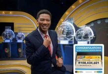 PowerBall Plus vs PowerBall Xtra: What changed under Sizekhaya National Lottery presenter standing beside a giant R108.4 million PowerBall jackpot cheque and live draw machines.