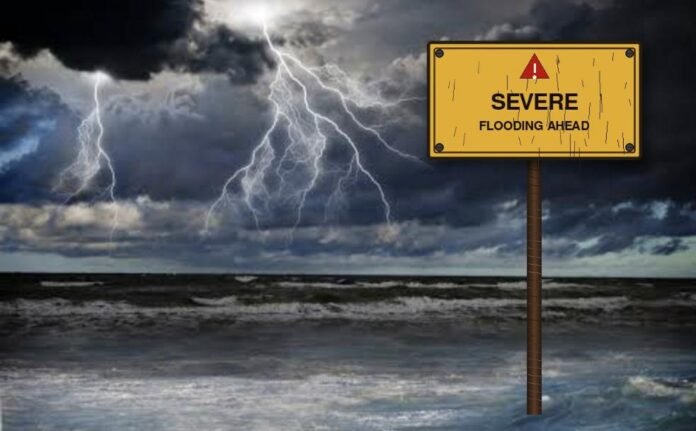 Lightning strikes over a stormy sea beside a severe flooding warning sign, South Africa
