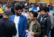 Home Affairs sets date for new digital asylum application system Foreign nationals queue outside a Home Affairs office with documents for asylum applications.