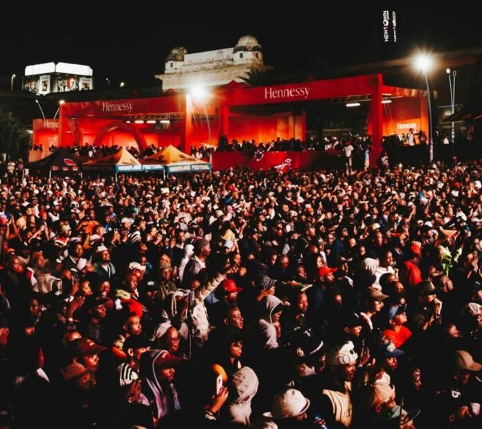 Crowd gathers beneath the illuminated Hennessy structure at Back to the City 2026 in Newtown, Johannesburg.