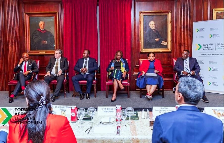 Senior African leaders and business executives take part in a FALS panel on investment, governance and digital transformation.Five people sit in a row on high-backed chairs inside an ornate wood-panelled room. They are dressed in formal business attire, with one woman wearing a red jacket and another wearing a colourful scarf. Red curtains and framed portraits form the backdrop, while a branded event banner stands to the right. Several attendees are visible seated at tables in the foreground.