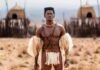 Shaka iLembe goes global as Season 3 first look is revealed Lemogang Tsipa as King Shaka in Shaka iLembe, holding a spear before thatched huts in a dry grassland