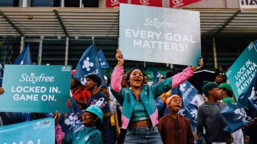 Banyana Banyana fans hold Stayfree Goals 4 Pads campaign signs during a stadium activation.
