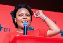 EFF presses criminal charges amid Bronkhorstspruit chlorine cover-up allegations Tshegofatso Mashabela, Tshwane MMC for Health, speaks at a red podium with her right fist raised.